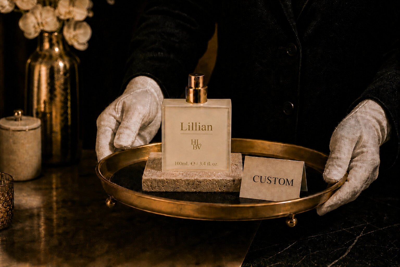 White-gloved hands presenting a gilt tray — fragrance and a CUSTOM card.